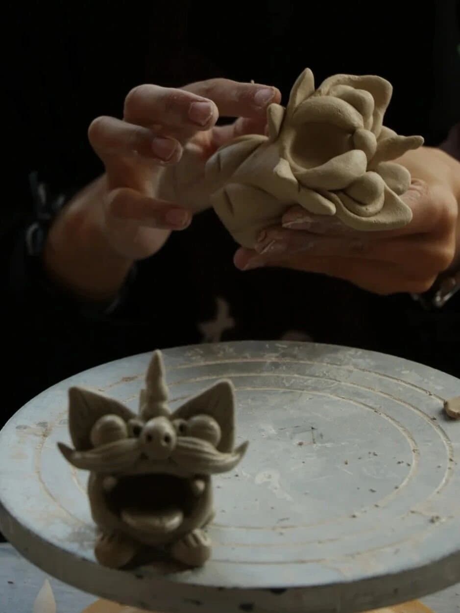Tile Cats — hands sculpting the guardian’s face
