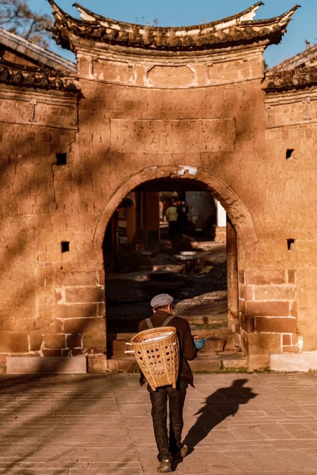 Shaxi Ancient Town — a traveler entering through an old town gate