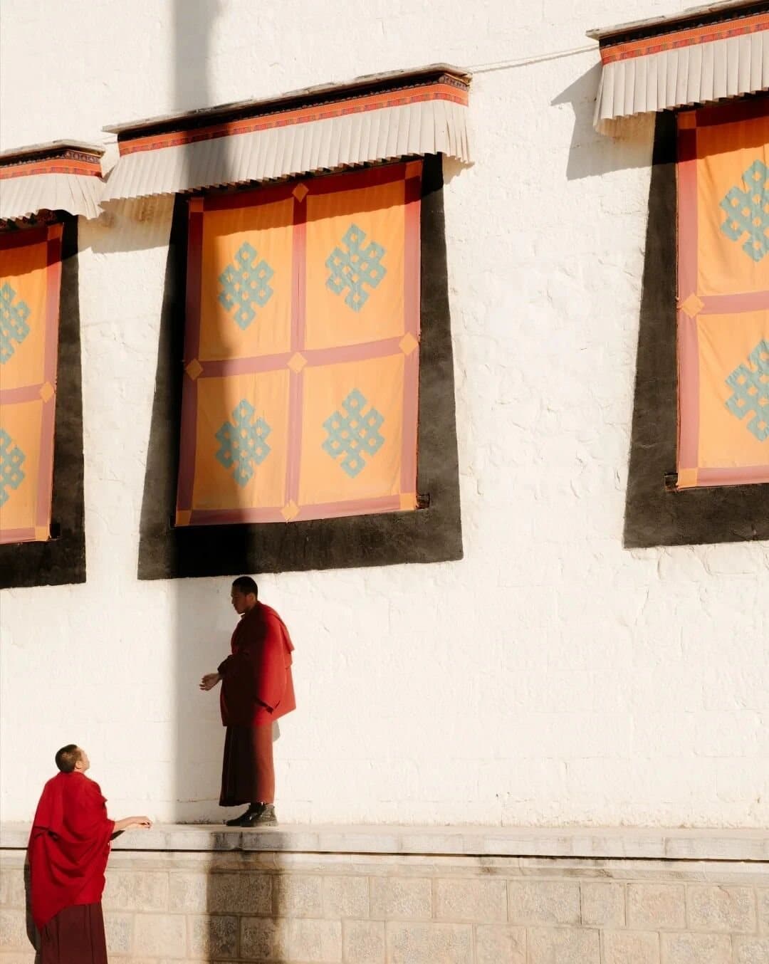 Ancient Tea Horse Road — a monk beside the painted windows of a monastery