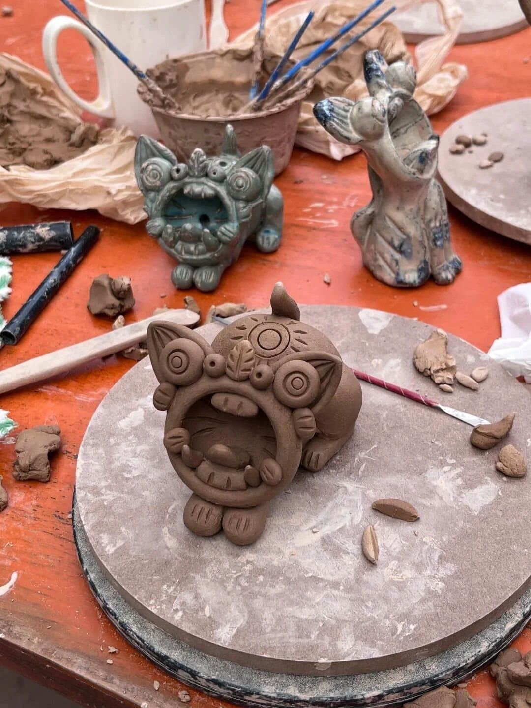 Tile Cats — an artisan shaping a tile cat in clay