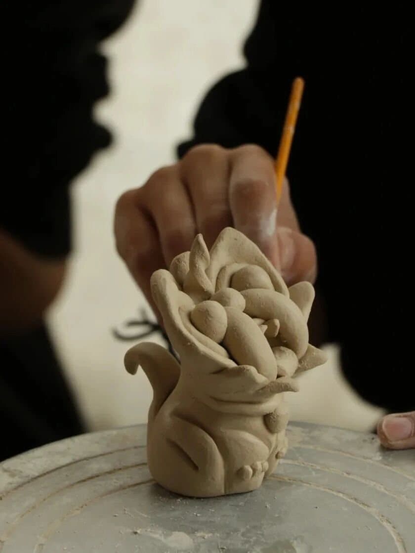 Tile Cats — an artisan refining a clay tile cat