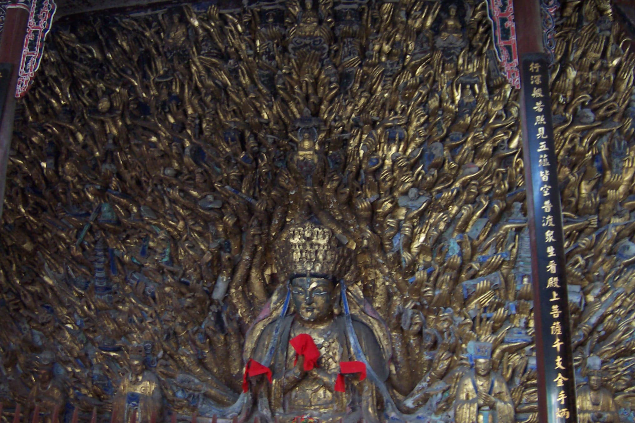 Close view of gilded hands, eyes and ritual objects on the Thousand-Hand Guanyin